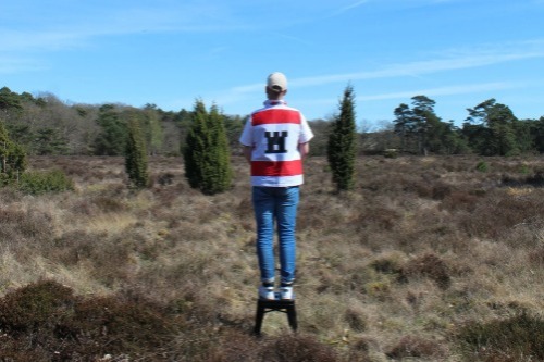 Man in de heide met shirt met logo van provincie Drenthe